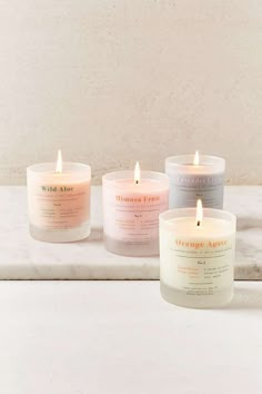 three candles sitting next to each other on top of a white counter with the words u o