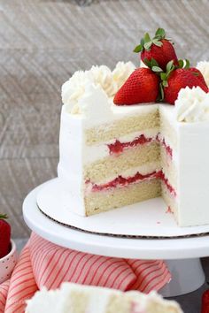 a strawberry mascarpone cake with white frosting and fresh strawberries on top