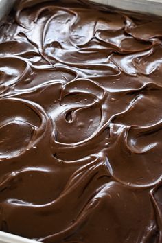 a pan filled with chocolate frosting sitting on top of a table