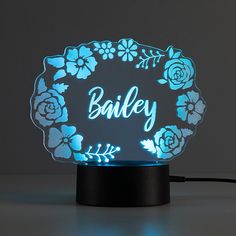 a personalized light up with flowers and the word bailey on it's side