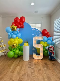 the room is decorated with balloons, stars and mario's house number 5 on it