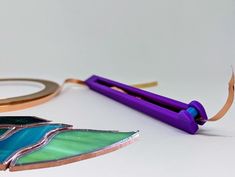 a pair of scissors and some crafting supplies sitting on a table next to each other