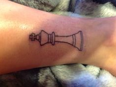 a person's arm with a tattoo on it that has a chess piece in the middle