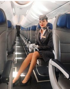 a woman sitting on an airplane with her legs crossed