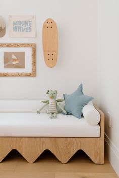 a white day bed sitting next to a wall with pictures on it