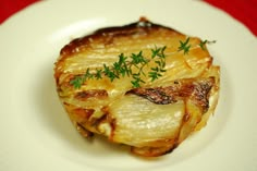 a white plate topped with food on top of a red table