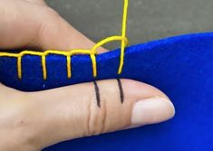 a person's finger with a yellow thread on it