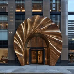 the entrance to an office building with large circular gold sculpture on it's side