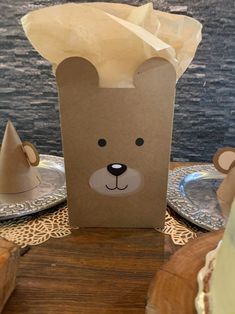 a brown paper bag with a bear face on it sitting on top of a wooden table