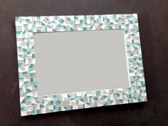 a mirror that is sitting on top of a table with blue and white mosaic tiles