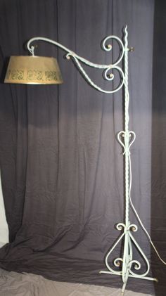 a lamp that is on top of a table next to a curtained window with curtains in the background