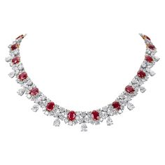 This spectacular necklace is built around 22 oval-cut Burma rubies ranging in size from approximately 2.50 carats to 0.95 carats totalling approximately 38 carats. The rubies exhibit a rich vivid red hue and excellent crystal transparency. Each ruby is accentuated by a diamond horseshoe comprised of 189 round brilliant diamonds weighing approximately 29.70 carats. There are 22 diamond drop sections containing a total of 22 pear shape, 44 marquise, and 22 round brilliant diamonds weighing approxi Luxury Fusion Style Ruby Necklace, Chinese Pendant, Ruby Diamond Necklace, Ruby And Diamond Necklace, Diamond Jewelry Designs, Ruby Necklace, Cluster Necklace, Mom Jewelry, Expensive Jewelry