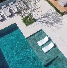 an aerial view of a pool with lounge chairs