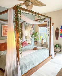 a bedroom with a canopy bed and plants on the wall