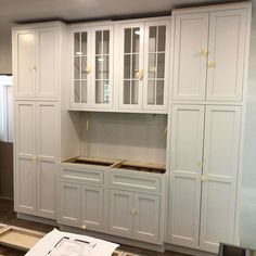 a kitchen with white cabinets and wood flooring in the middle of construction work on the walls