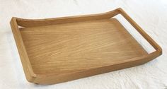 an empty wooden tray sitting on top of a white sheet