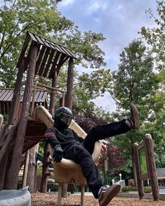 a man sitting on top of a wooden slide