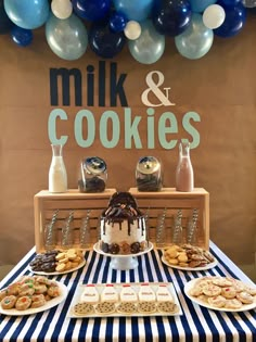 a table topped with lots of desserts and cookies on top of a blue striped table cloth