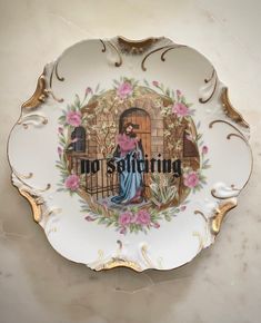 a decorative plate with the words no sitting on it and a painting of a woman