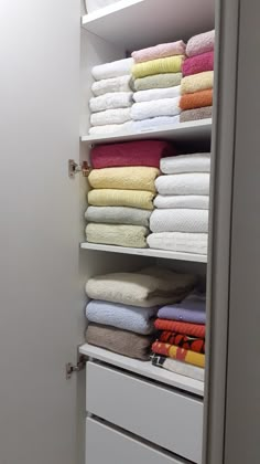 an organized closet with folded towels and folded towels