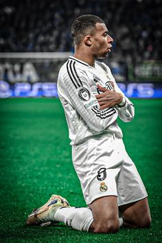 a soccer player sitting on the ground with his arms crossed and looking off into the distance