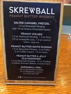 the menu for skewball peanut butter whiskey is displayed on a wooden table top