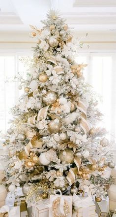 a white christmas tree with gold and silver ornaments