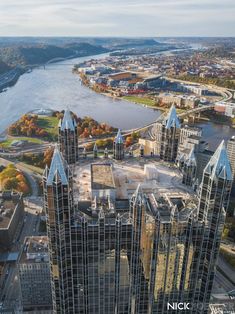 an aerial view of a city with skyscrapers and river in the background, taken from above