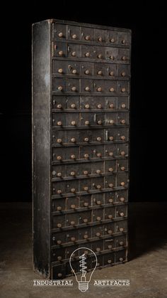 an old wooden cabinet with many drawers and knobs on the front, against a black background