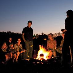 a group of people sitting around a campfire