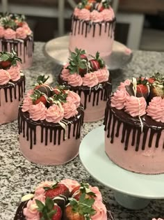 there are many cakes with chocolate and strawberries on the top one is covered in pink icing