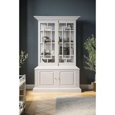 a white china cabinet with glass doors and shelves in the middle of a living room