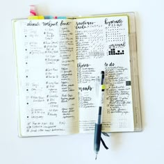 an open planner with writing on it and a pen resting on top of the page