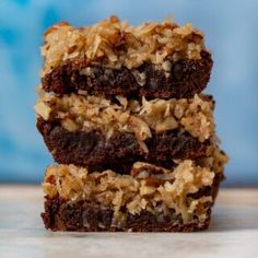 three brownies stacked on top of each other with coconut flakes all over them