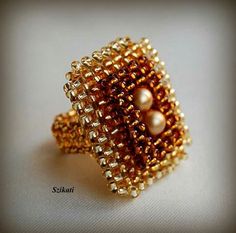 a close up of a ring with pearls on it