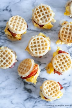 mini waffle sandwiches with bacon and cheese on them sitting on a marble counter top