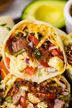 two burritos stacked on top of each other with meat, cheese and veggies