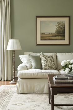 a living room with green walls and white furniture