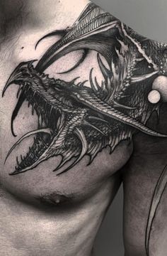 a black and white photo of a man's chest with dragon tattoos on it