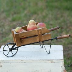 a wooden wagon filled with apples on top of a table