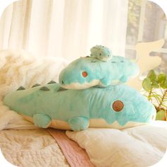 two stuffed animals sitting on top of pillows