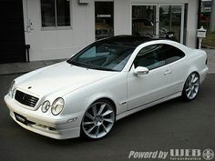 a white car parked in front of a building