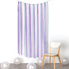 a room with balloons and streamers hanging from the ceiling, next to a chair