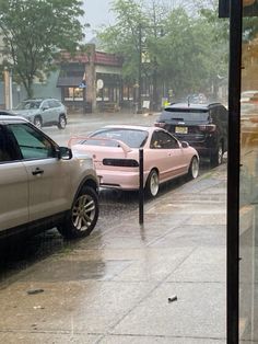 cars are parked on the side of the road in the rain