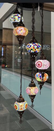 a chandelier hanging from the ceiling in front of a building with many different colored lights