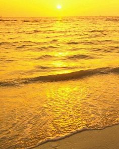 the sun is setting over the water at the beach