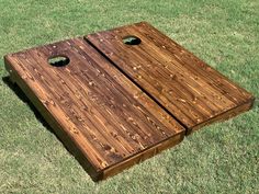 a close up of a wooden board on the ground with holes in it and grass