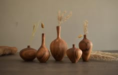 five wooden vases sitting next to each other on a table