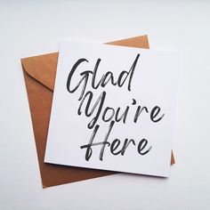 a card with the words glad you're here written in black ink on it