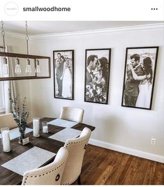 a dining room table with chairs and pictures on the wall